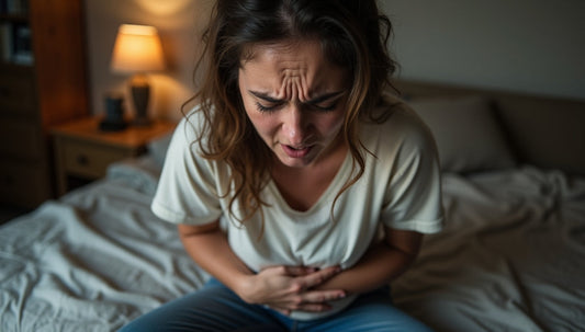 A stressed person holding their stomach, indicating digestive discomfort caused by anxiety or tension.